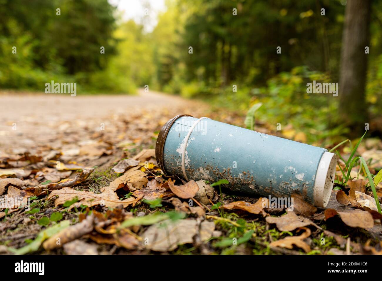 Vieja taza de café desechable en el bosque. Tema del reciclaje de  plásticos, la contaminación y el calentamiento global. Eliminar el impacto  de las industrias alimentarias en el medio ambiente Fotografía de