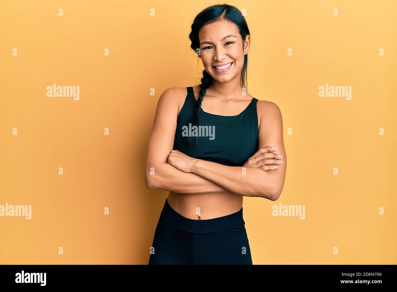 Hermosa mujer hispana con ropa deportiva sobre fondo amarillo cara