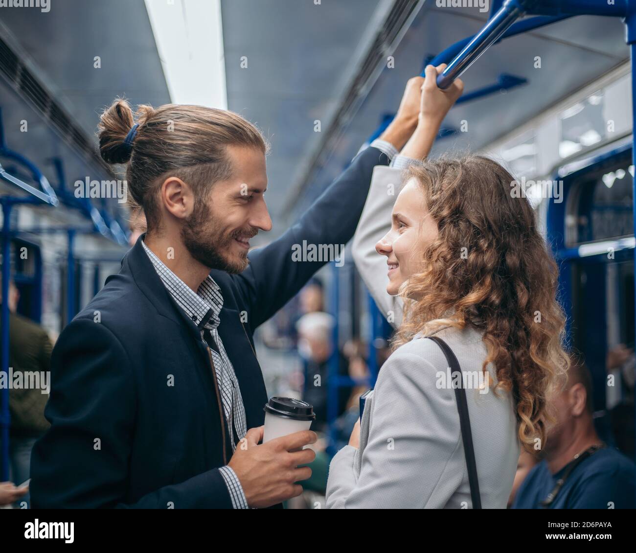 hombre y mujer enamorados mirándose unos a otros en un tren subterráneo. Foto de stock