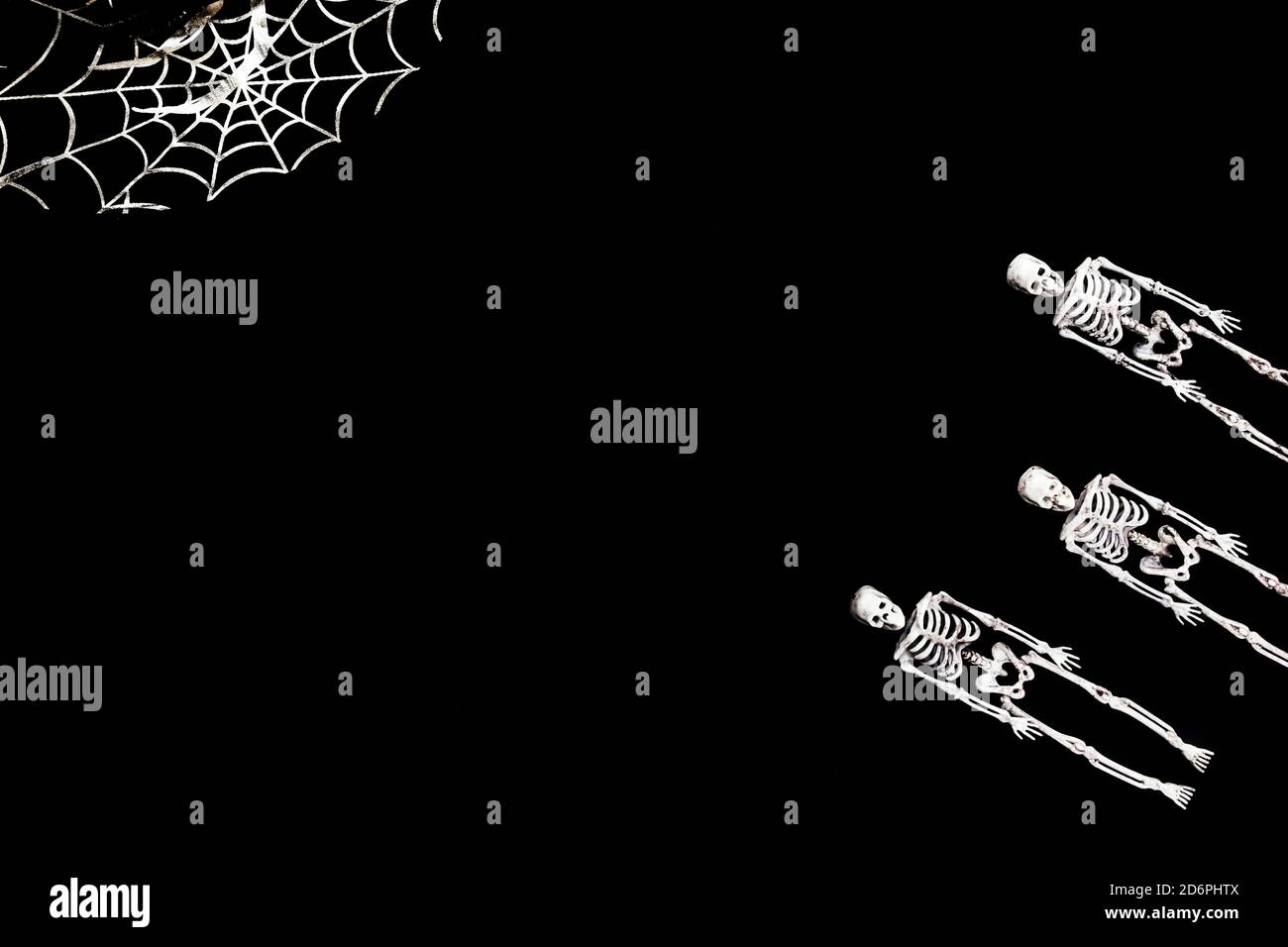 Tarjeta de decoración de Halloween con esqueletos para el diseño de la celebración. Fondo negro. Lay plano. Colocar para texto. Foto de stock