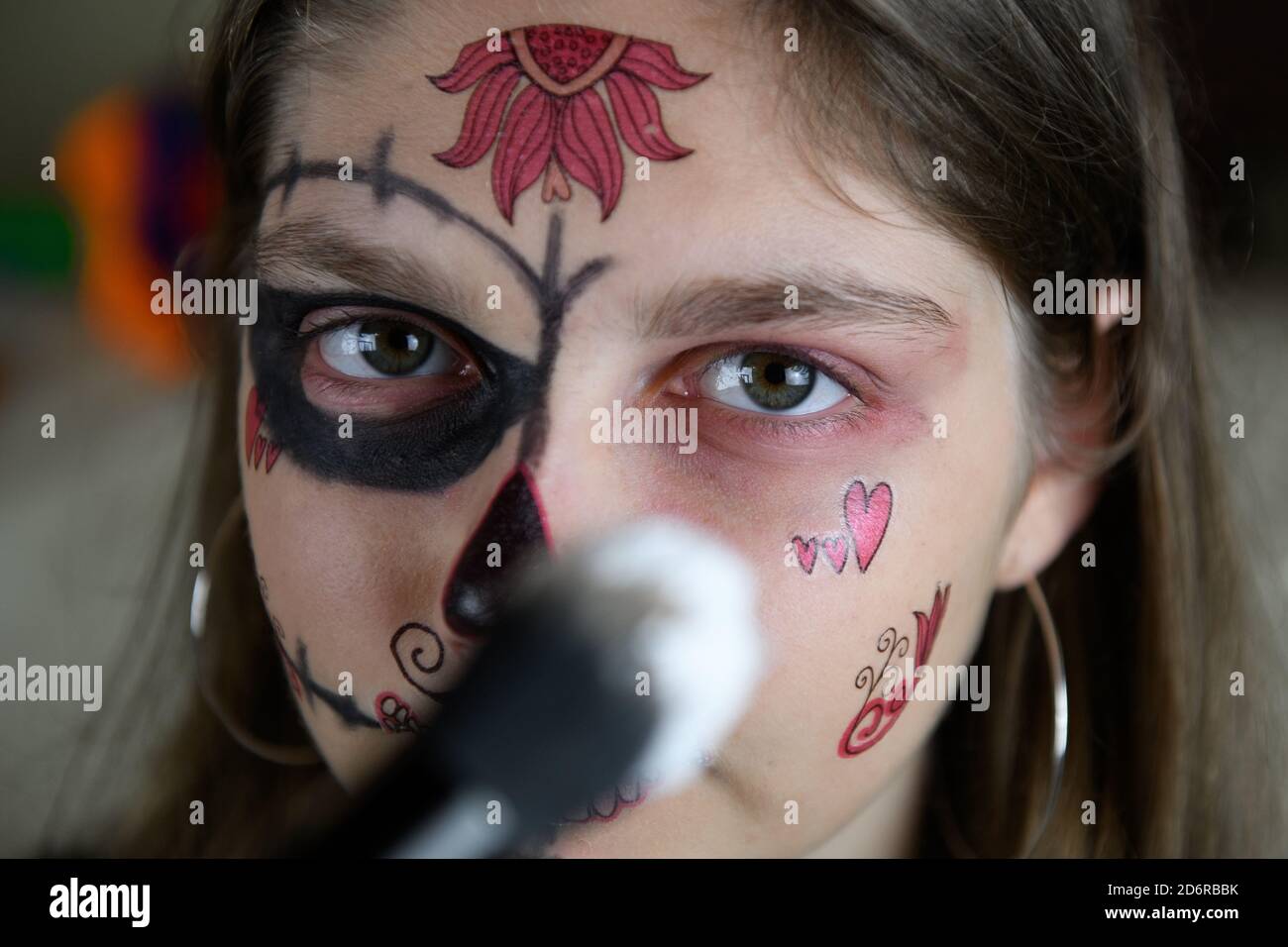 Una chica haciendo un maquillaje de Halloween para el día de los muertos,  celebrando Halloween en casa Fotografía de stock - Alamy