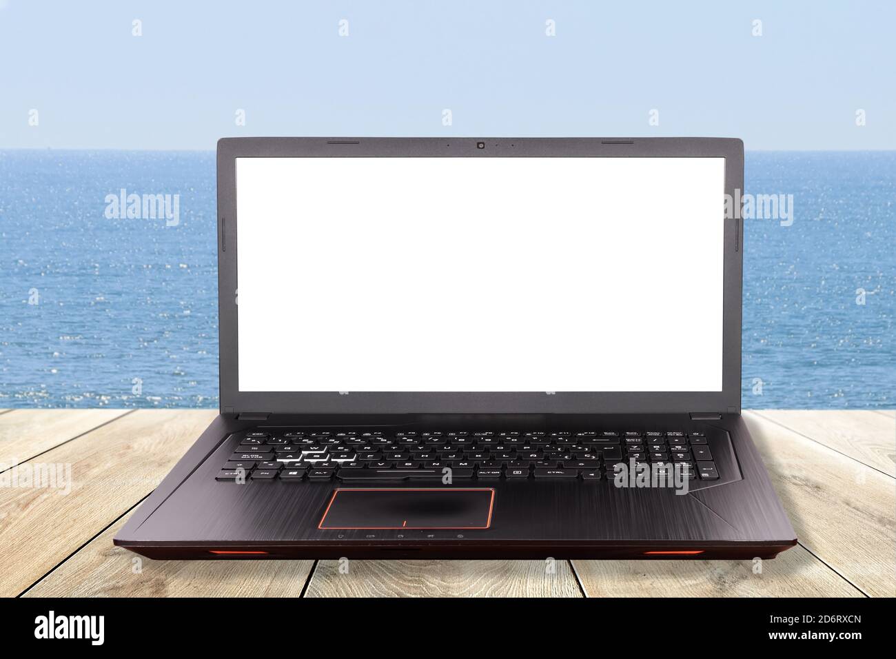 Portátil negro sobre una mesa en la playa como concepto para teletrabajo, teletrabajo, teletrabajo Foto de stock