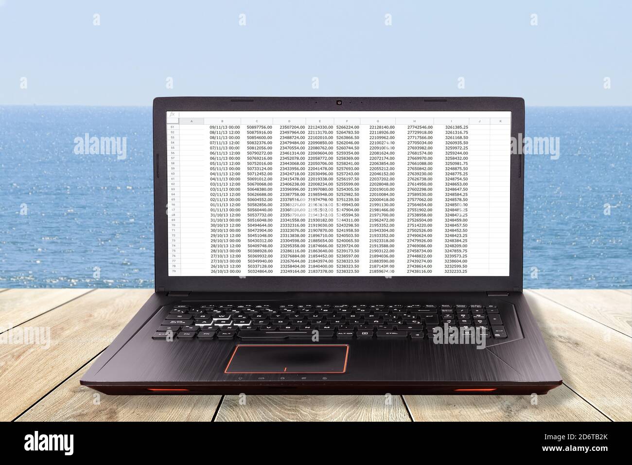 Portátil negro sobre una mesa en la playa como concepto para teletrabajo, teletrabajo, teletrabajo Foto de stock