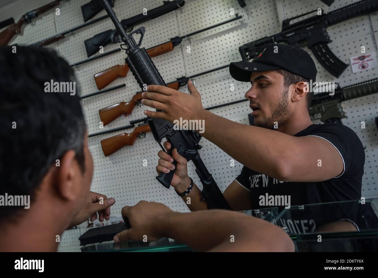 Najaf, Irak. 19 de octubre de 2020. Un distribuidor de armas (R) demuestra el mecanismo de un rifle de estilo AR-15 a un cliente en una tienda que vende armas de fuego y municiones, donde se permite a las personas comprar armas autorizadas después de emitir los permisos necesarios de las autoridades de seguridad. Crédito: Ameer al Mohammedaw/dpa/Alamy Live News Foto de stock