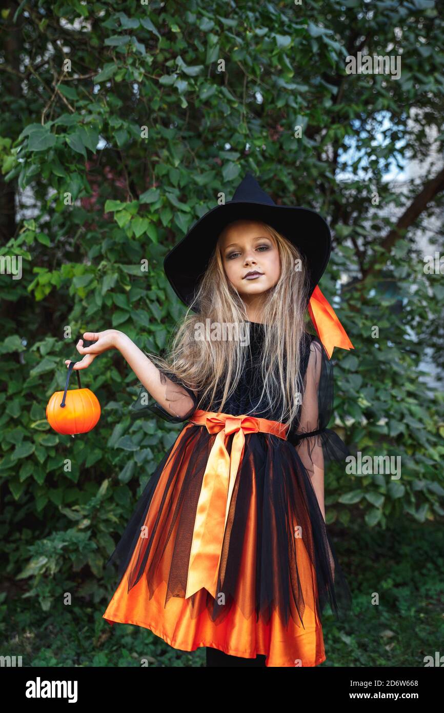 Niña divertida en traje de bruja para Halloween con calabaza Jack al aire  libre Fotografía de stock - Alamy
