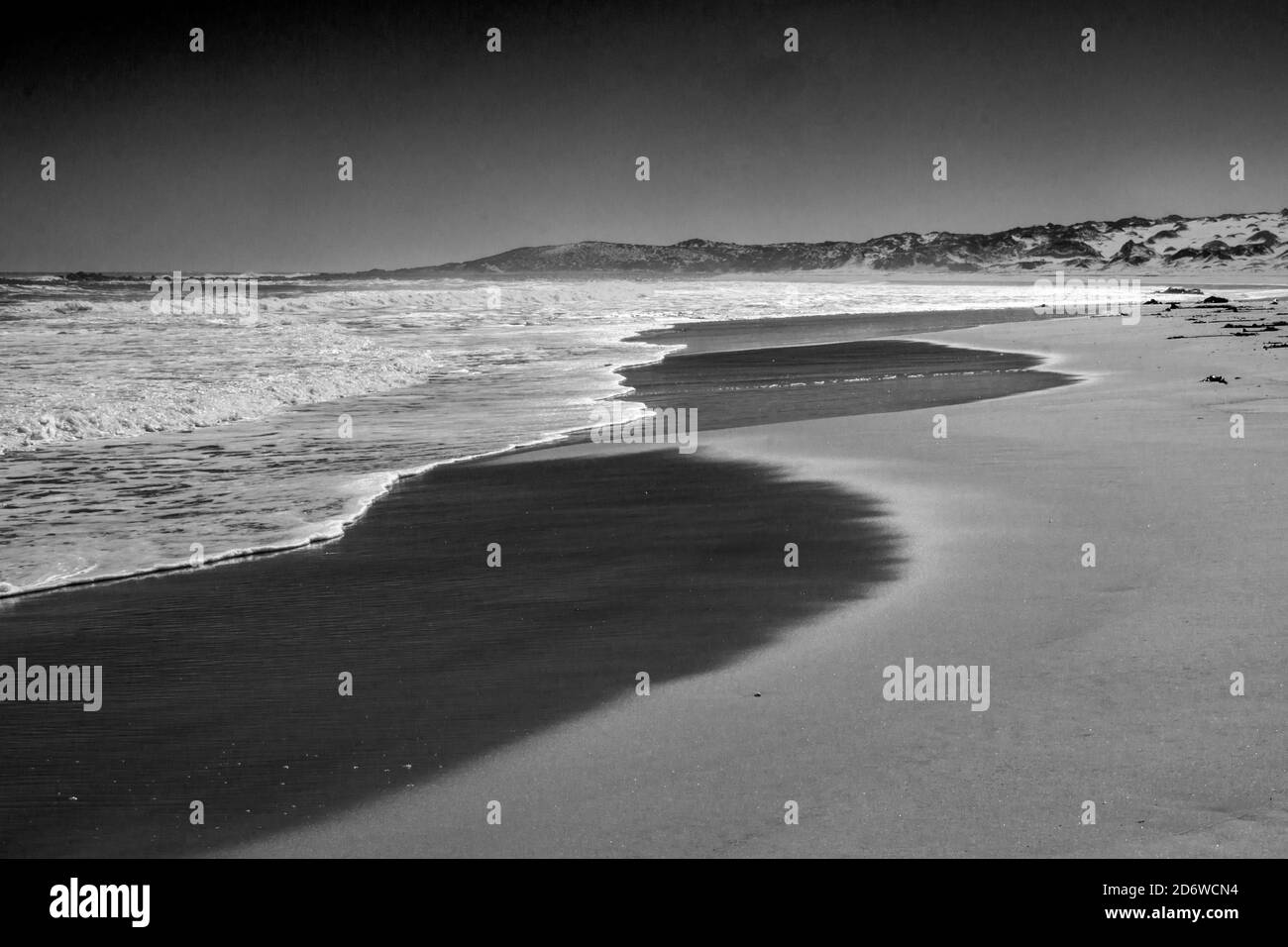 Vista de una playa desierta, protegida y arenosa a lo largo de la costa oeste de Sudáfrica, en Monocromo Foto de stock