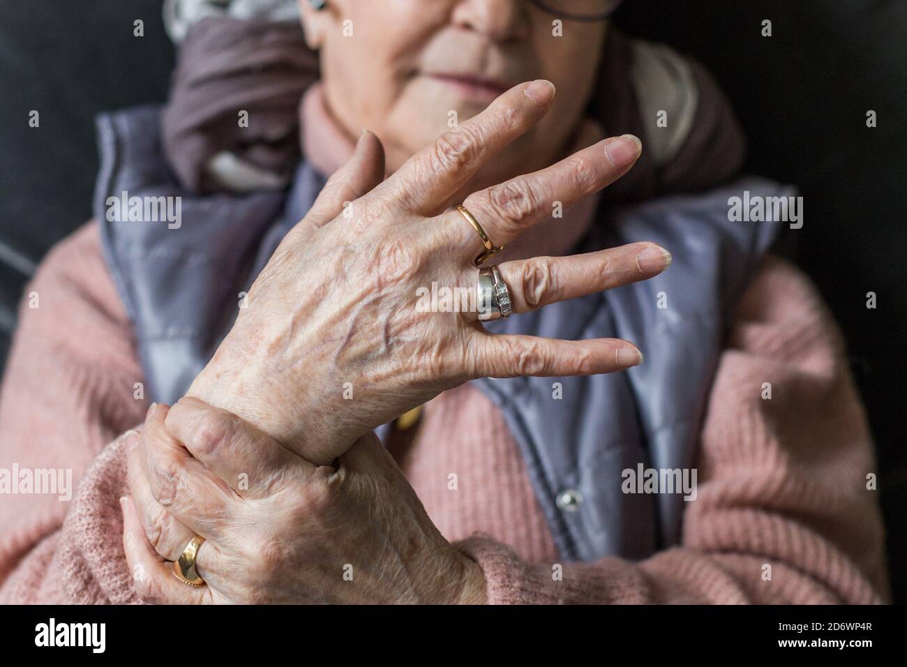 Mujer de más edad que sufren un dolor articular en la mano. Foto de stock