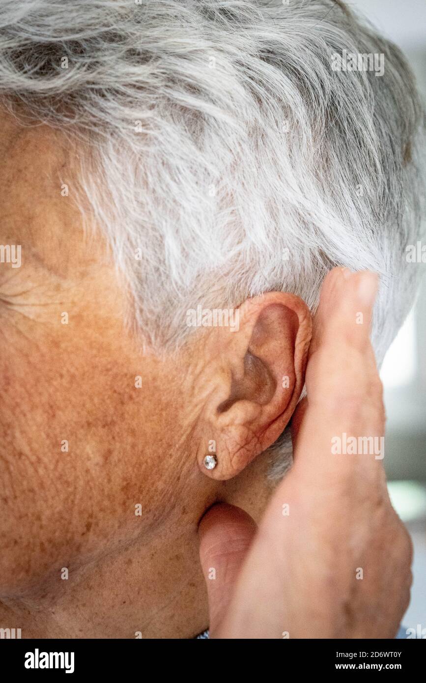 Mujer tocando la cabeza y el oído con dolor de oído. Foto de stock