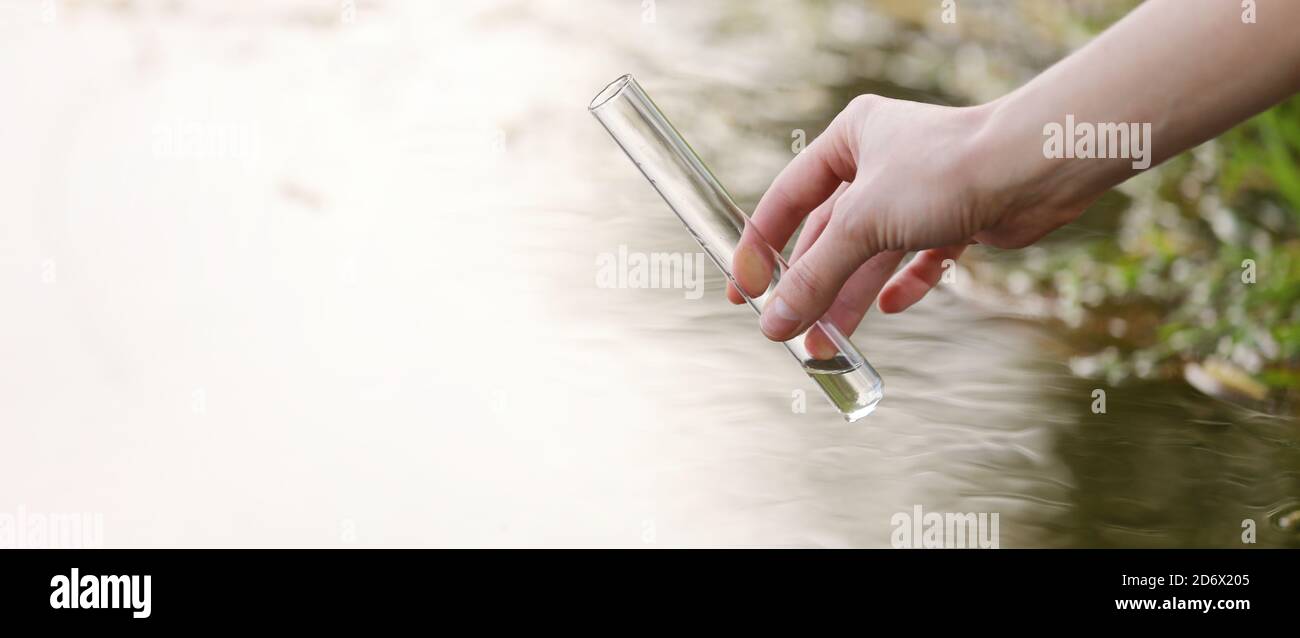 Una muestra de agua del río. Consumo de agua. Abstracción de agua. Banner agua de muestra. El concepto de un ambiente limpio. Foto de stock