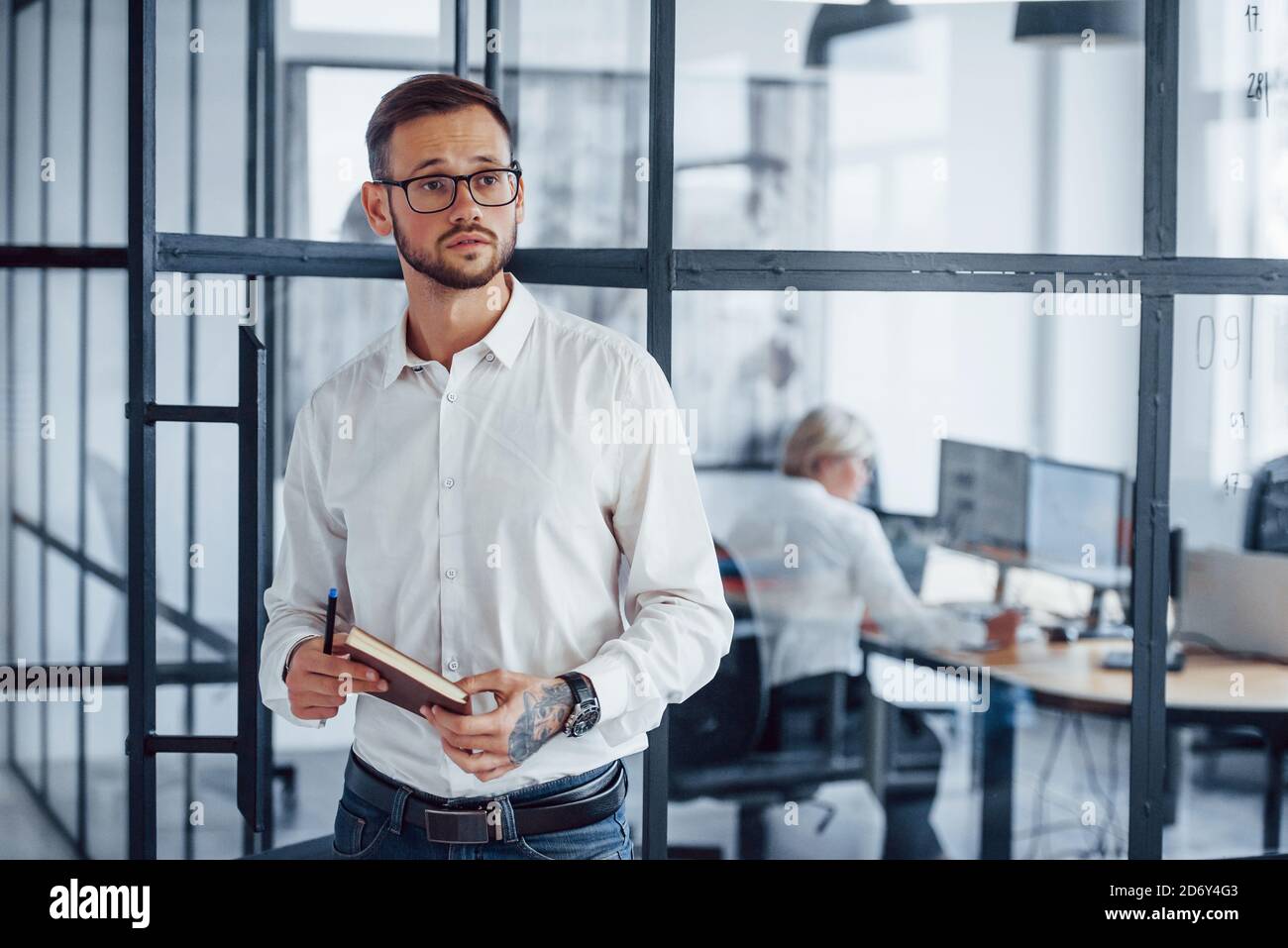 Retrato de un joven hombre de negocios con ropa formal que se pone de pie  oficina Fotografía de stock - Alamy