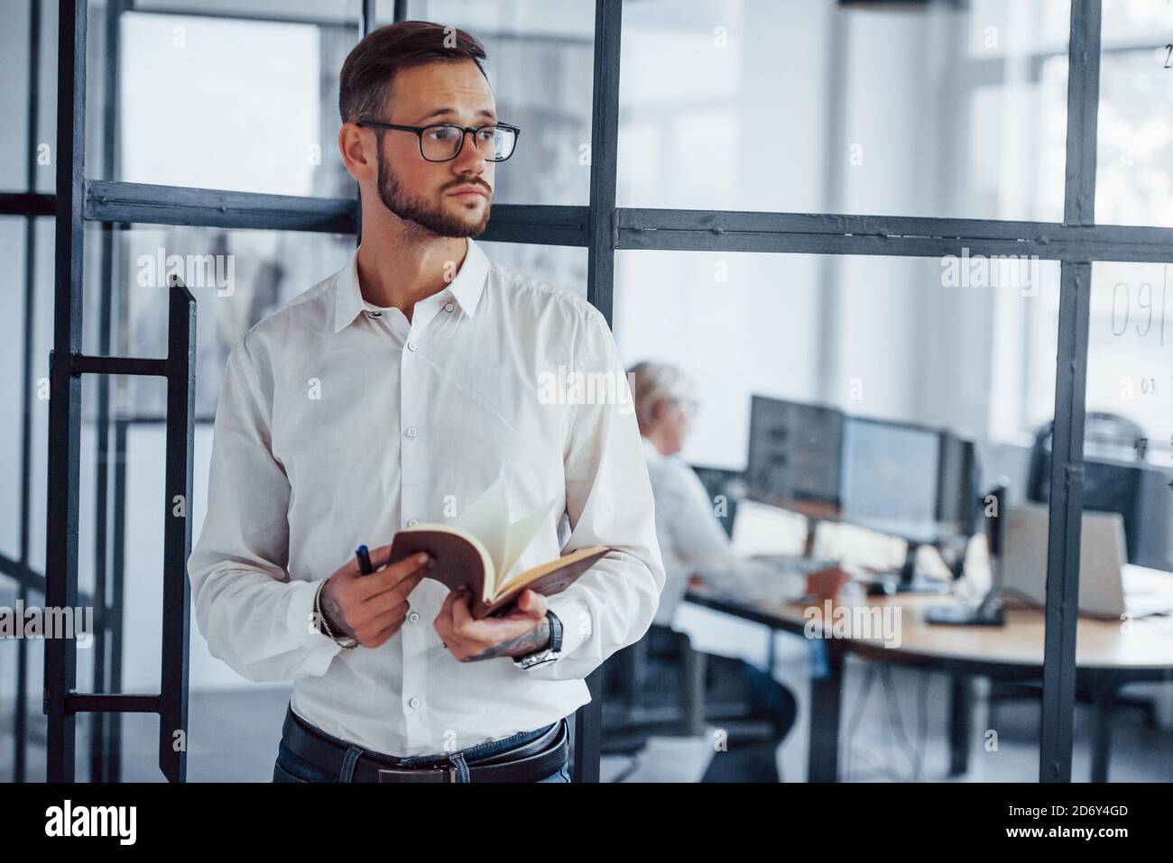 Retrato de un joven hombre de negocios con ropa formal que se pone de pie oficina Foto de stock