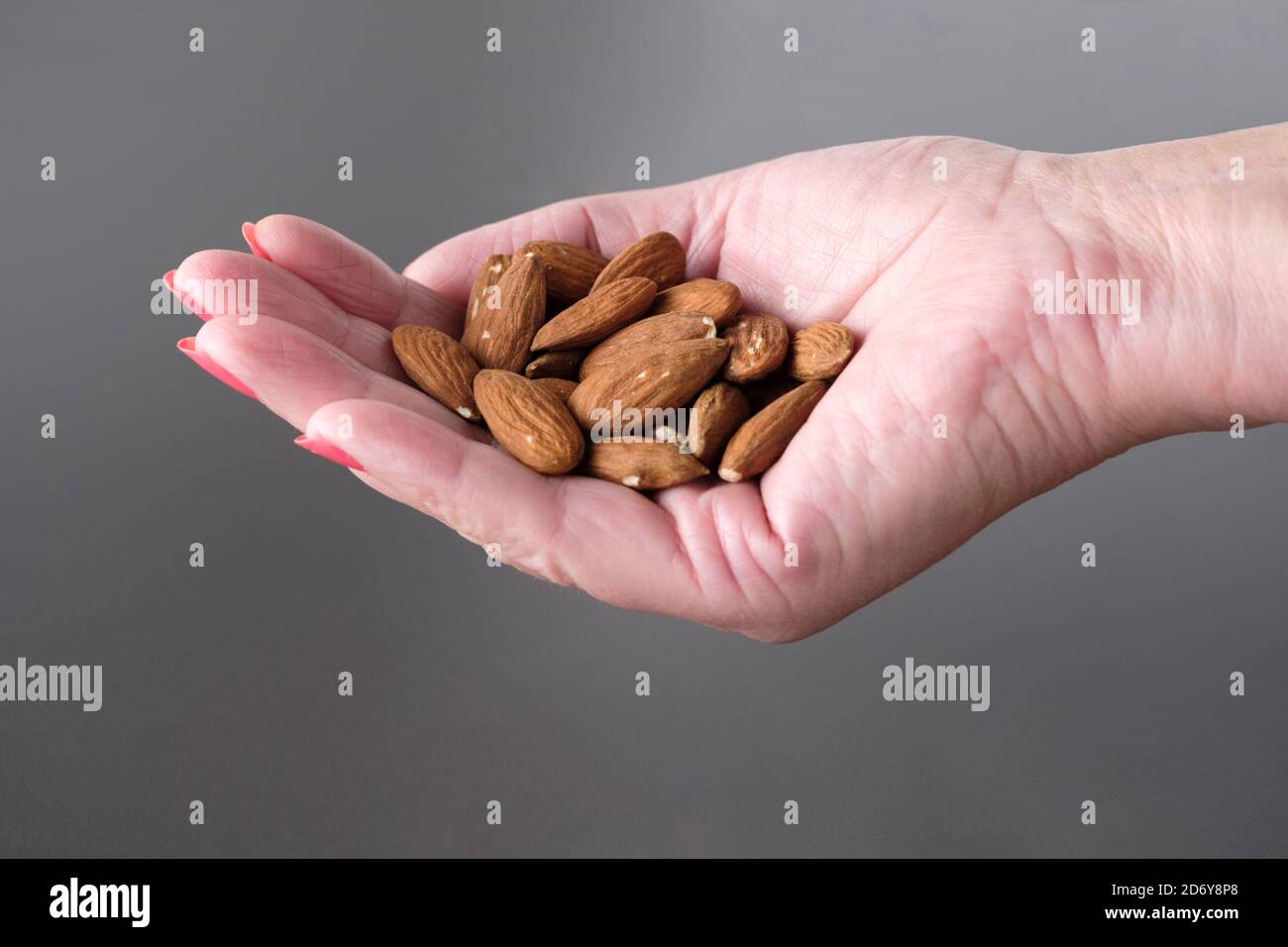 Un puñado de nueces de almendra, una onza o 28g. Altamente nutritivo y rico en grasas saludables, antioxidantes, vitaminas y minerales. Un refrigerio diario saludable Foto de stock