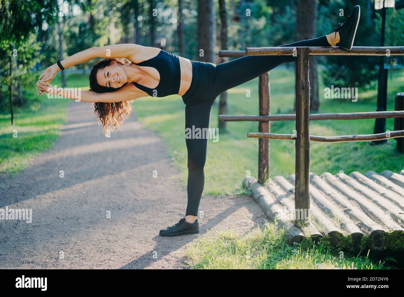 Mujer activa delgada en ropa deportiva pilates ejercicios y estiramientos  al aire libre, tiene expresión alegre, buena flexibilidad, disfruta de la  mañana de entrenamiento en los mares Fotografía de stock - Alamy