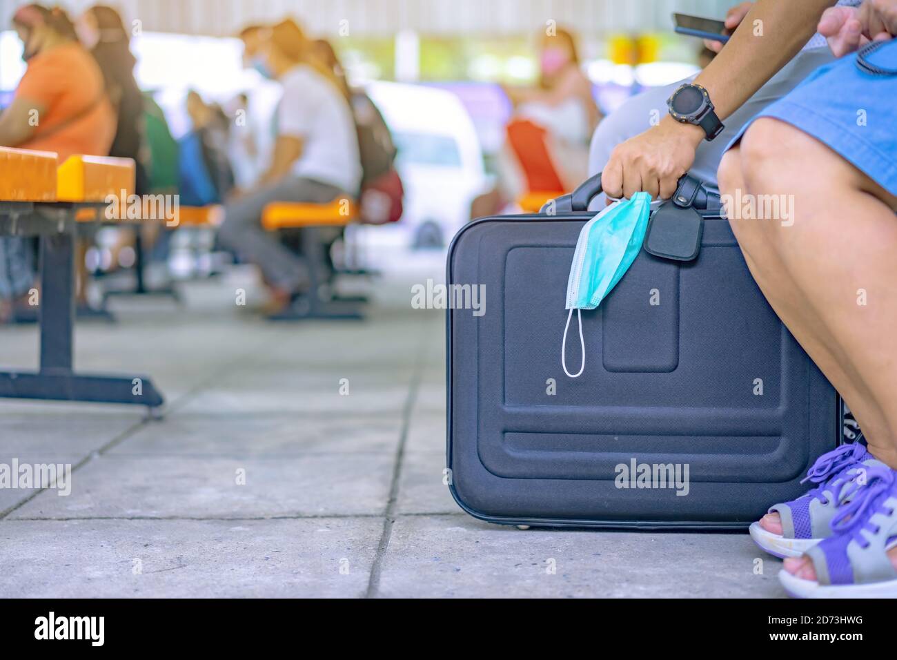 El turista masculino se prepara para llevar equipaje y máscara quirúrgica  para prevenir el virus de la Corona (Covid-19) para viajar en transporte  público en la estación de transporte. Nueva norma Fotografía