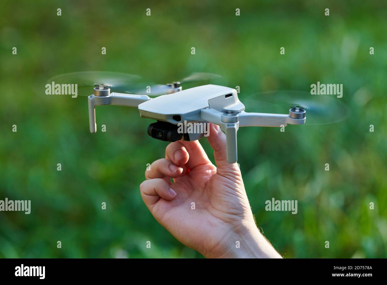 El mando del cuadruplicador está a mano del operador. Un pequeño drone  aterriza a mano después de tomar vídeo y fotos. Control remoto de la  entrega de aire y espía Fotografía de