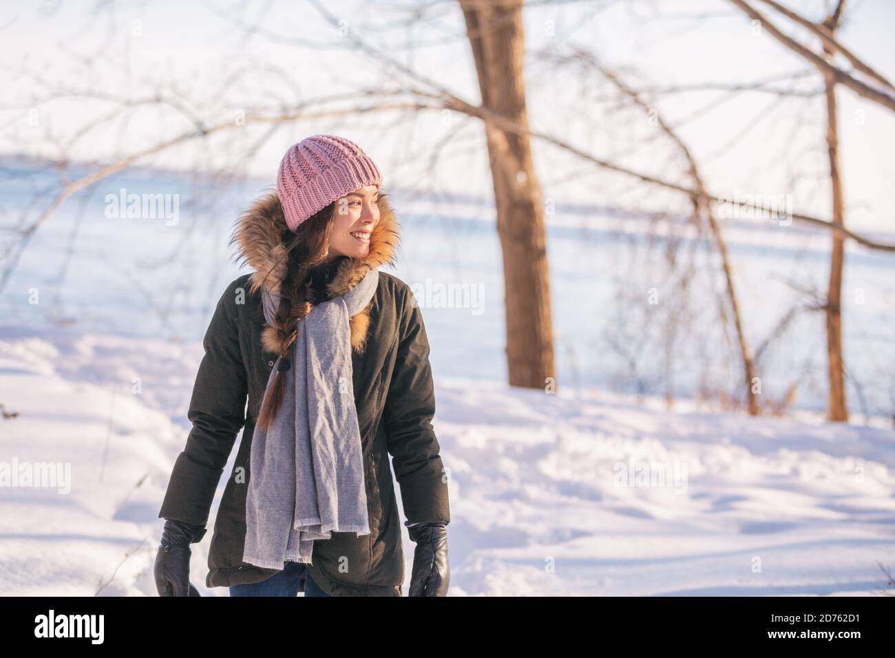 Mujer caminando por el camino en el parque en invierno. Relajación en la  naturaleza de la nieve. Mujer con ropa de abrigo, gorro de punto con pompón  y abrigo de piel Fotografía