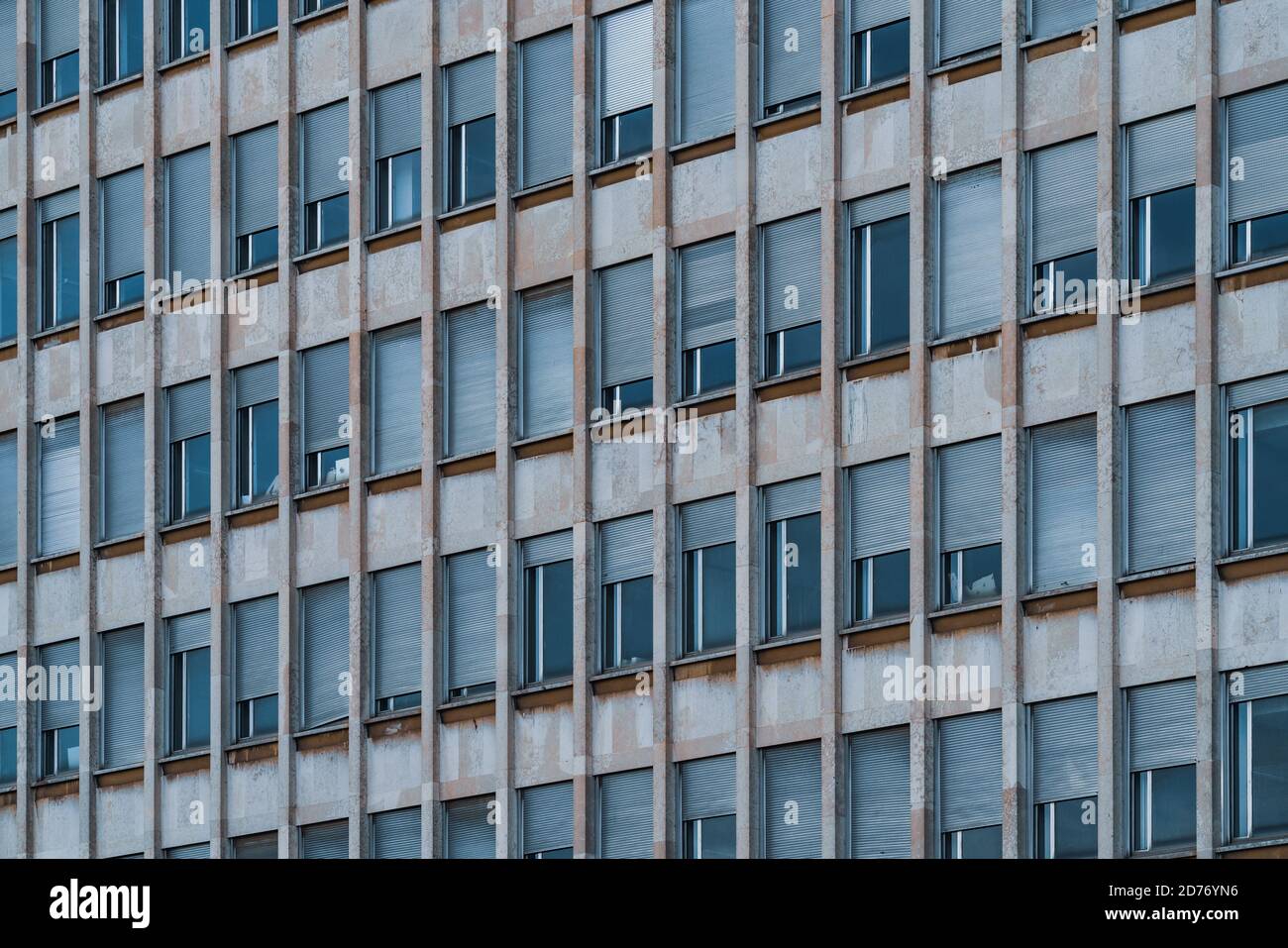 Filas de ventanas con persianas enrollables en la fachada de un edificio  urbano Fotografía de stock - Alamy