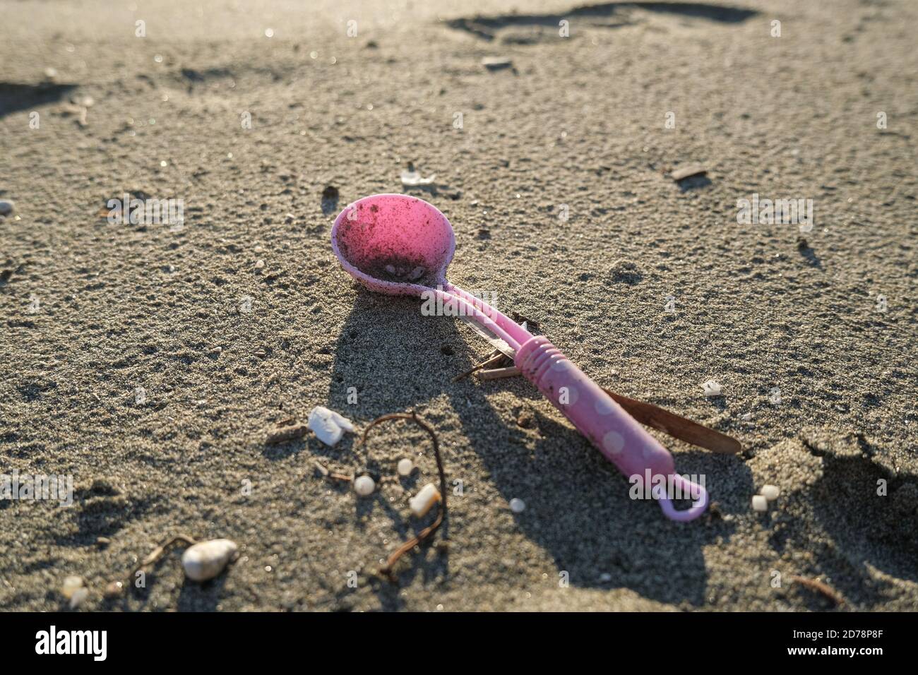 Cuchara de plástico niños juguete descartado en el sucio ecosistema marino contaminado, planeta daños por contaminación Foto de stock
