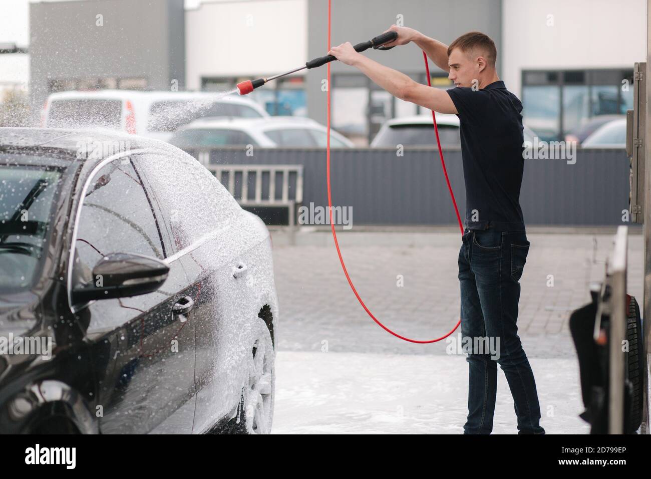 Limpieza del coche con espuma activa. Hombre lavando su coche en