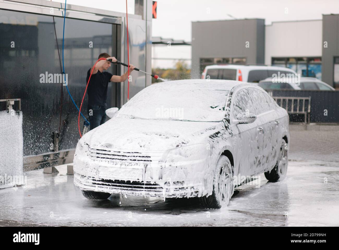 Coche en espuma activa en un lavado de coches de autoservicio