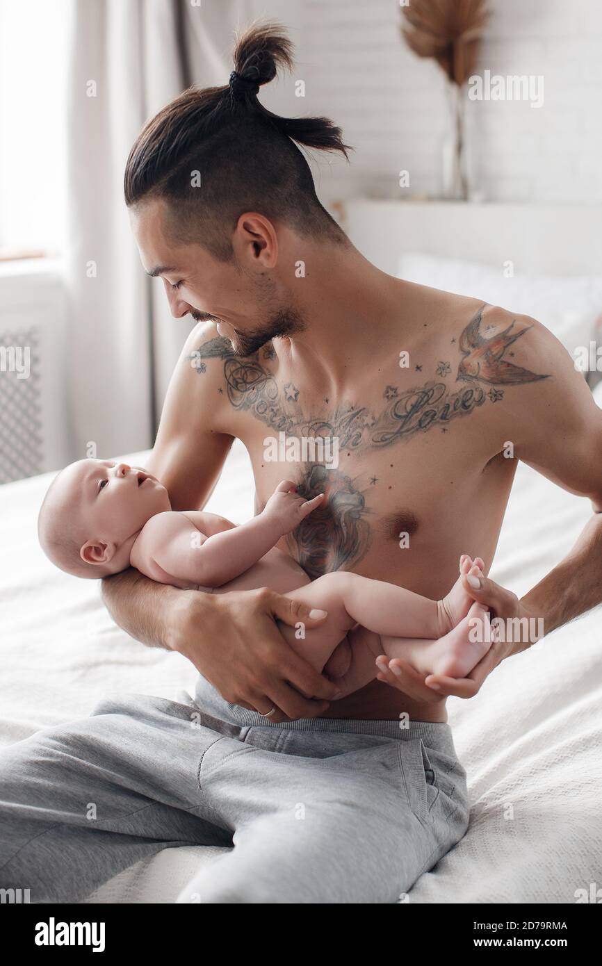 hombre con bebé. familia feliz en casa. padre feliz con lindo bebé de dos  meses tumbado en una cama liviana en casa Fotografía de stock - Alamy