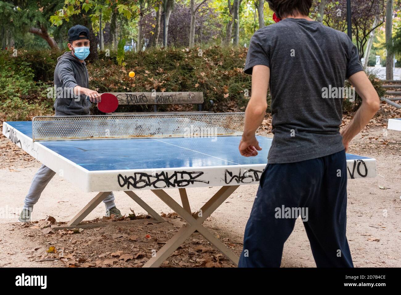 Dos chicos jugando ping pong en un parque de Madrid durante la pandemia de  COVID-19. Llevan máscaras protectoras Fotografía de stock - Alamy