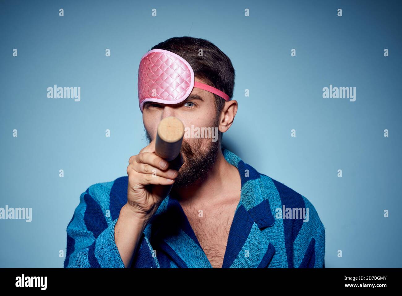 hombre con rodillo y en azul máscara de sueño rosa modelo de emoción de la vista recortada de la túnica Foto de stock