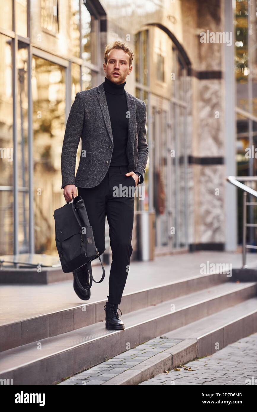 Hombre con elegante formal y bolsa está fuera contra el moderno Fotografía de stock - Alamy