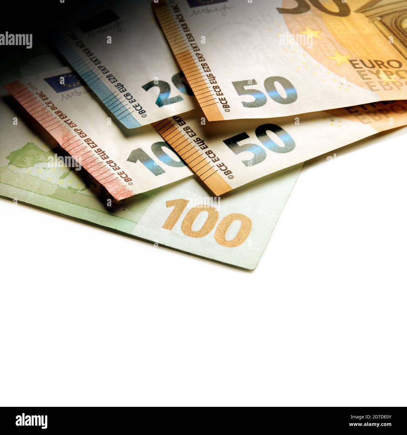 Enfoque poco profundo contra un montón de billetes en euros usados diferentes valores con un efecto de luz concentrada Foto de stock