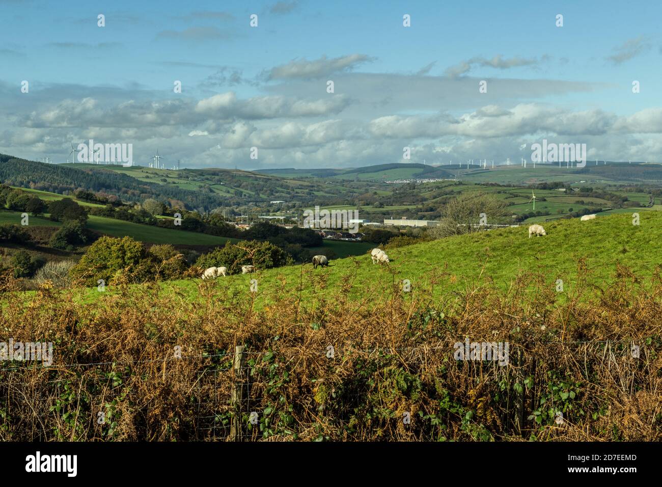 Un paisaje del sur de gales desde una ladera fuera de Llantrisant. En la distancia están los aerogeneradores y en la distancia media es un parque industrial. Foto de stock