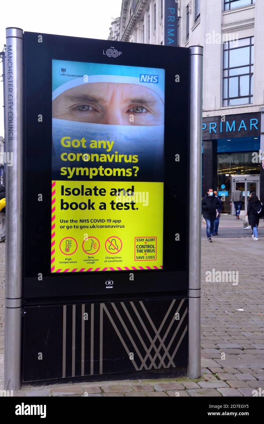 Covid 19 o señalización y publicidad de coronavirus en Manchester, Gran Manchester, Inglaterra, Reino Unido. Un signo iluminado de NHS insta a las personas a hacerse una prueba si tienen síntomas del virus. Foto de stock