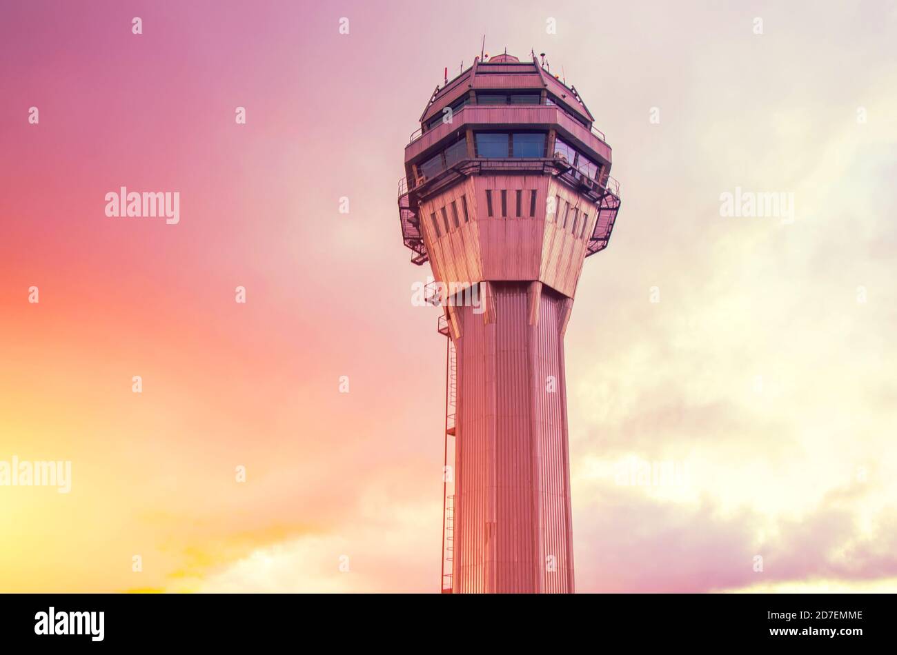 Torre de control de tráfico del aeropuerto solo con el fondo de la puesta de sol naranja rosa cielo y nubes Foto de stock