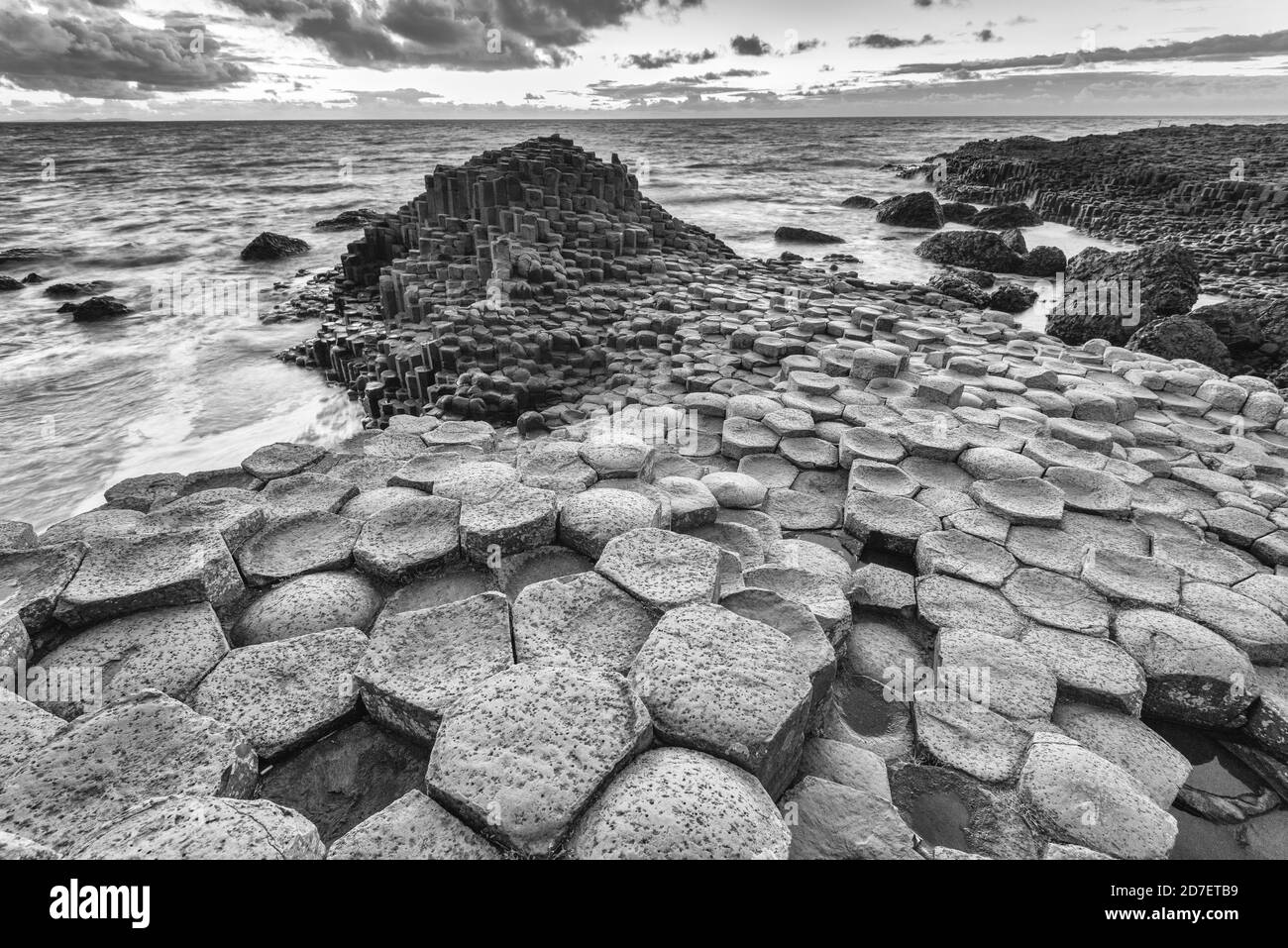 Puesta de sol en la Calzada del Gigante, un sitio declarado Patrimonio de la Humanidad por la UNESCO con unas 40,000 columnas hexagonales en la costa de Antrim en Irlanda del Norte. Foto de stock