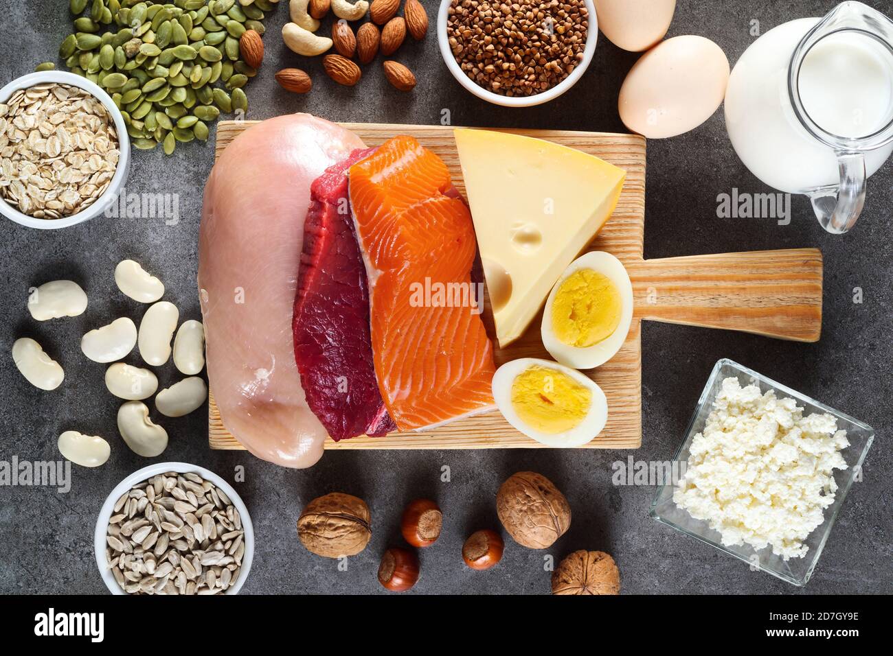Alimentos ricos en proteínas como carne, pescado, productos lácteos, huevos, trigo sarraceno, avena, nueces, frijoles, semillas de calabaza y semillas de girasol. Vista superior. Foto de stock