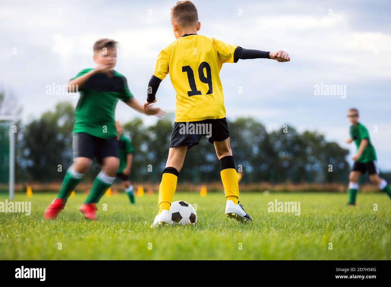 Los chicos de los clubes de fútbol compiten en torneos al aire libre. Juego  de fútbol para niños de escuela. Los niños llevan camiseta de fútbol ropa  deportiva correr sobre hierba pi