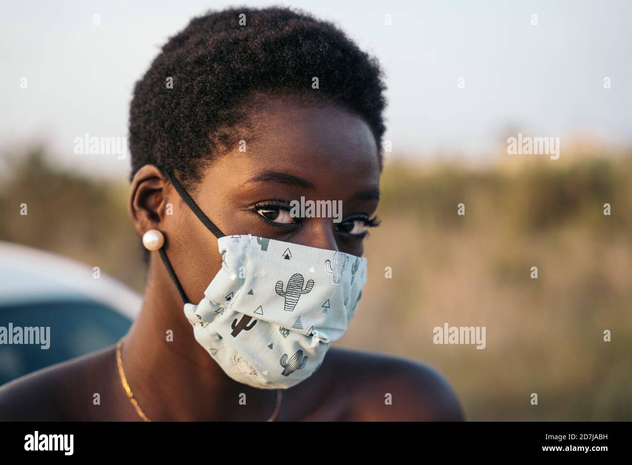 Mujer joven con máscara protectora en el campo Foto de stock