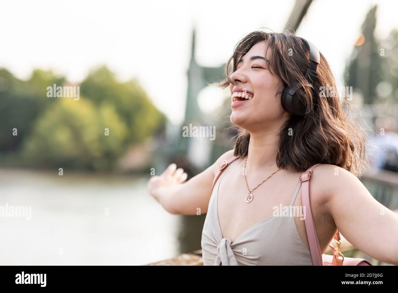 Hermosa mujer escuchando música a través de los auriculares en el día soleado Foto de stock