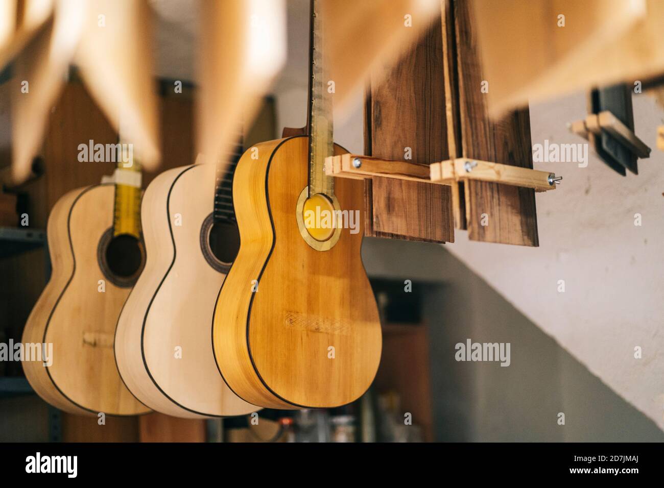 Guitarras colgando en una línea en el taller Foto de stock
