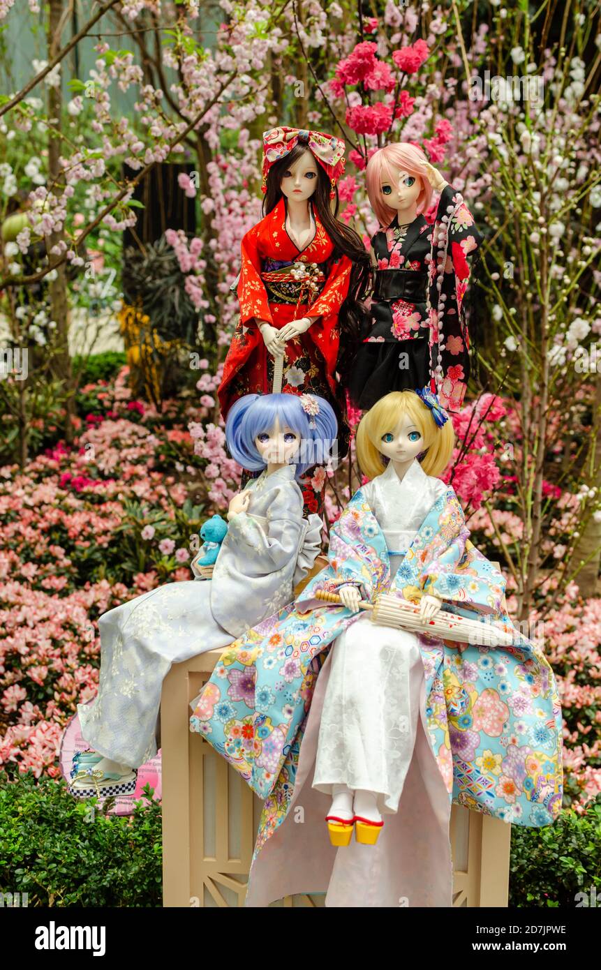 Muñeca japonesa de anime vestido con kimono y trajes de dama con sakura en  el fondo Fotografía de stock - Alamy