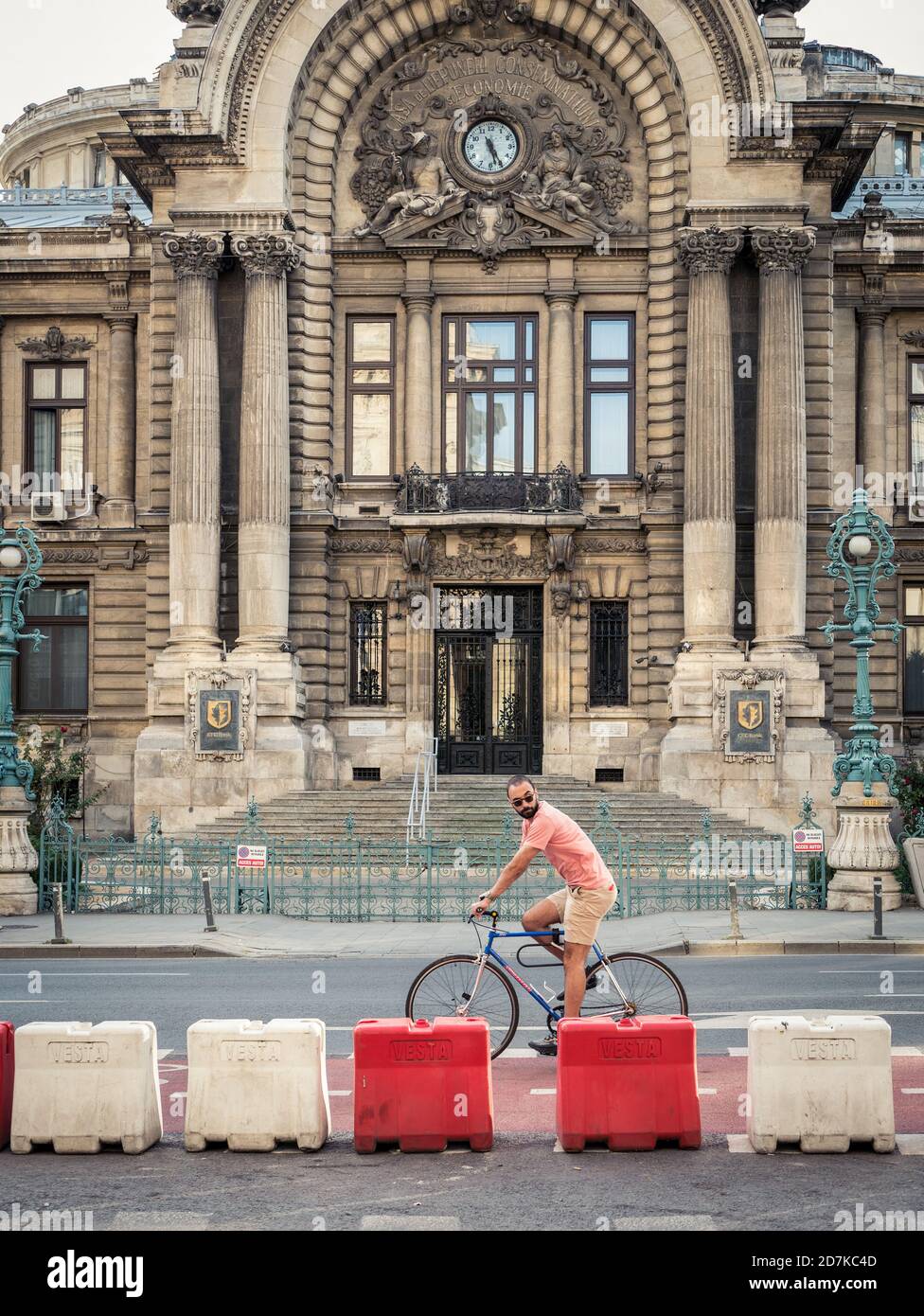 Bucarest/Rumanía - 10.02.2020: Hombre montando en bicicleta frente al Palacio de los depósitos y los envíos Foto de stock