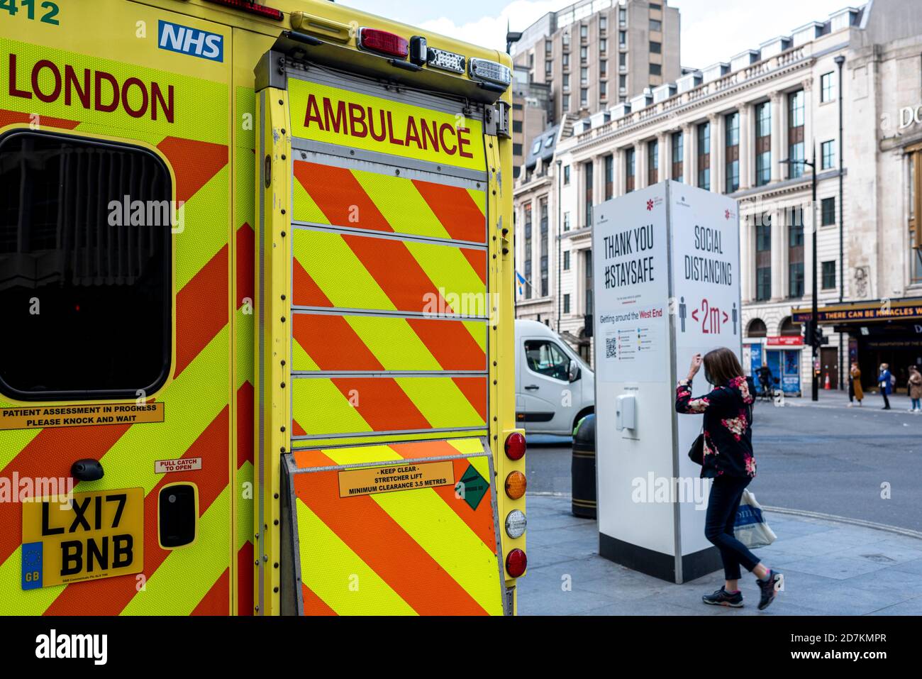 Londres, Reino Unido- Octubre 22 2020: Distanciamiento social Sign in background with the back of an UK Ambulance aparcado junto a él. Londres es... Foto de stock