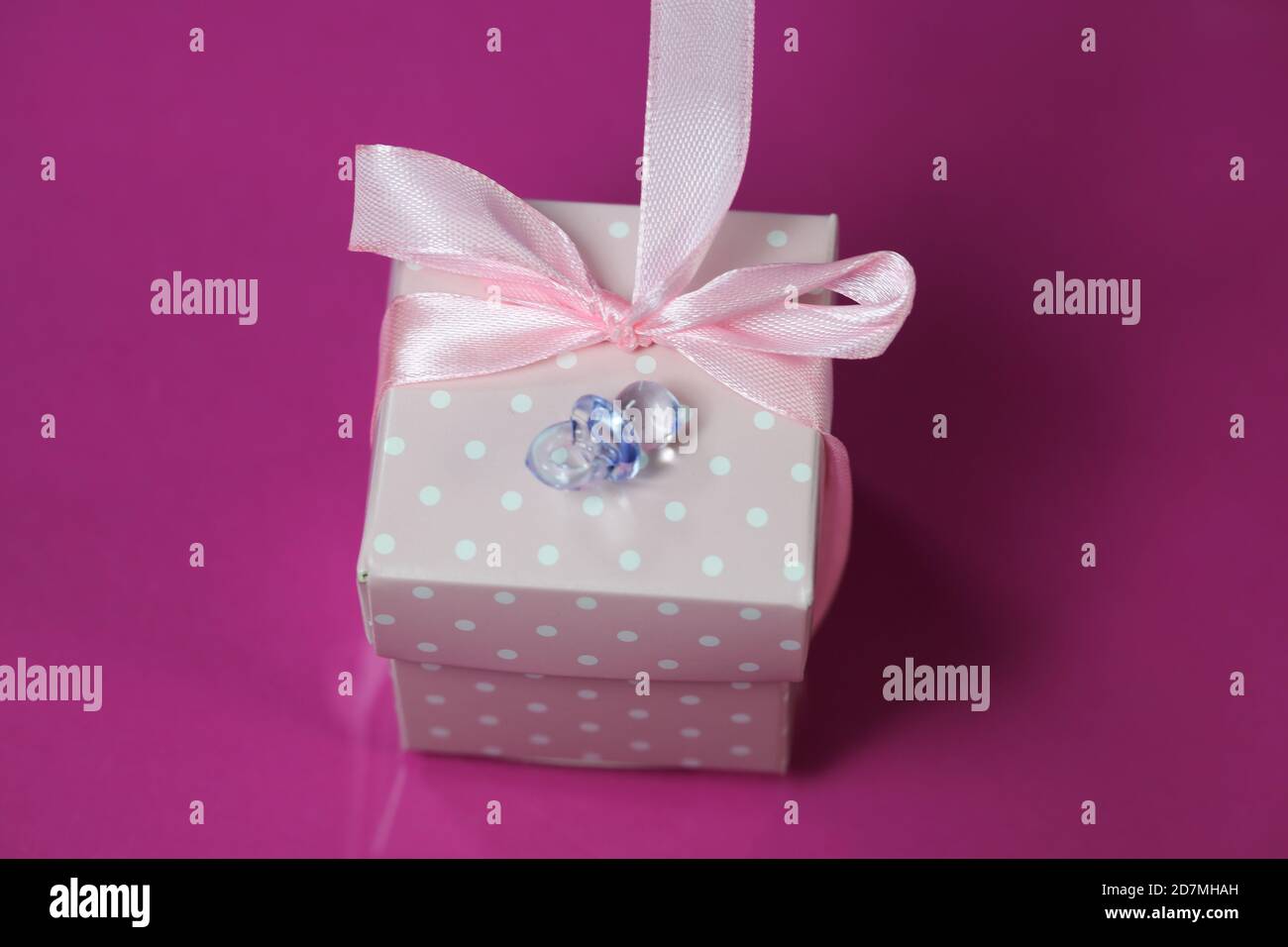 pequeño regalo en envoltura rosa, recién nacido, cumpleaños Foto de stock