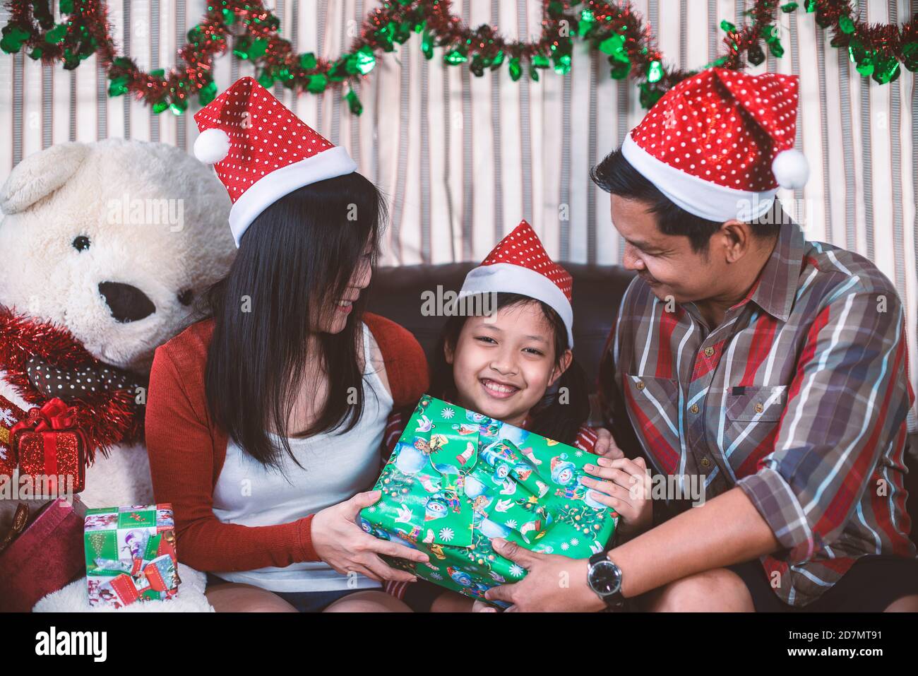 Feliz padres dando regalos de Navidad para la hija.Familia en el interior  de Navidad Fotografía de stock - Alamy