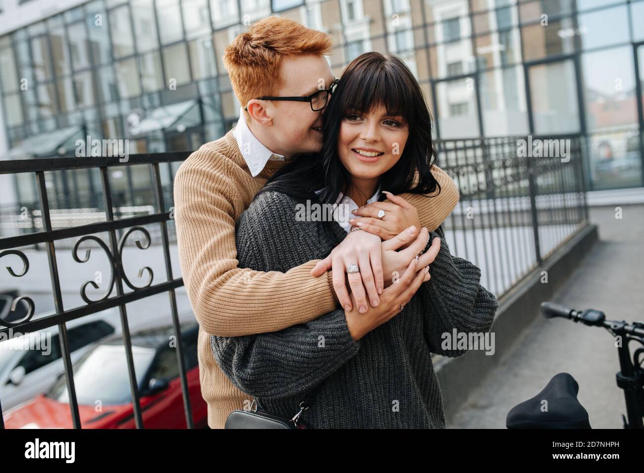 Una pareja linda, un hombre abrazando a su novia desde atrás, enterró su rostro en su cabello Foto de stock