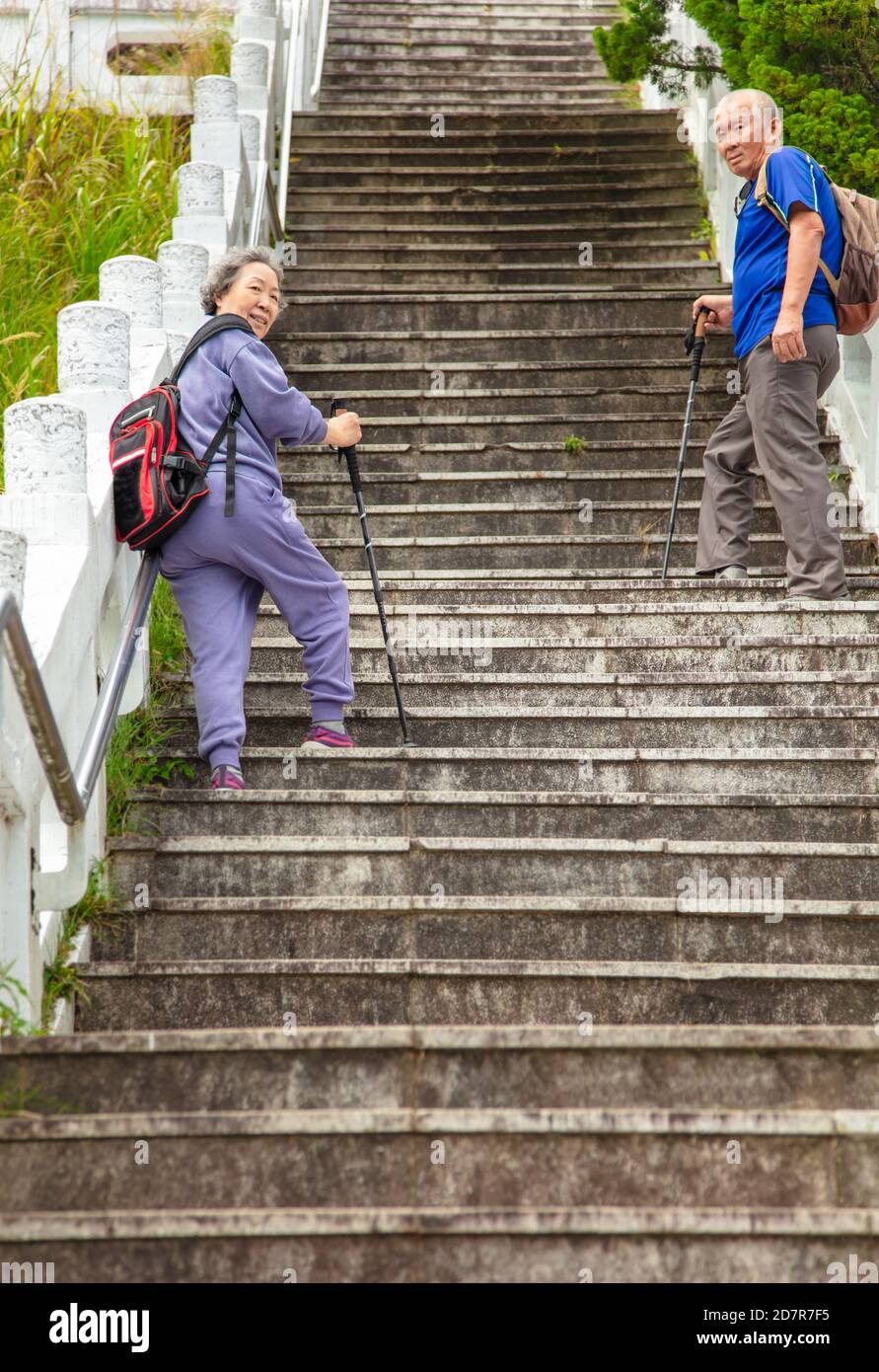 una pareja mayor que intenta subir las escaleras Foto de stock