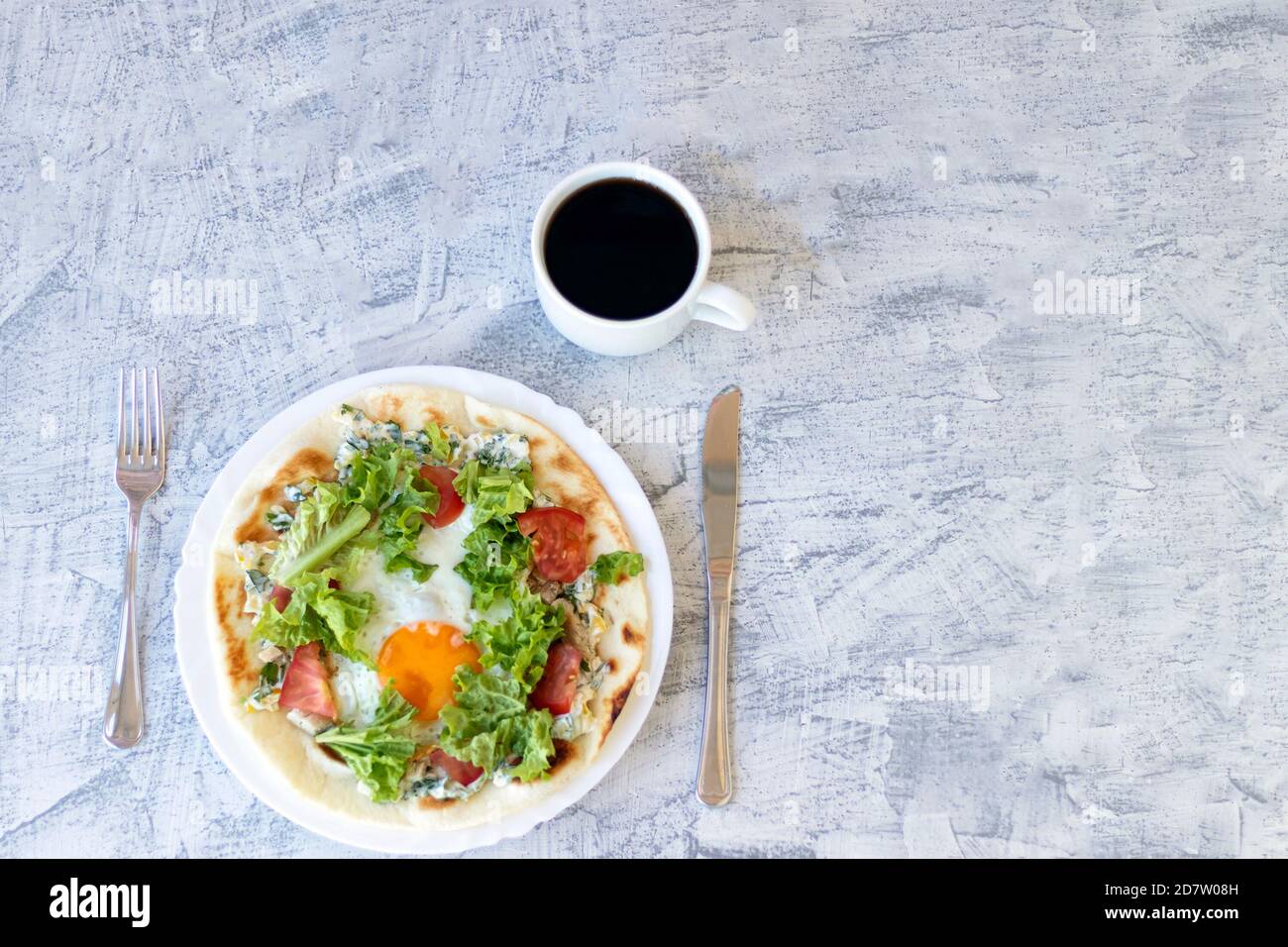 Desayuno italiano con café. Piadina con huevo, tomate y ensalada. Delicioso desayuno servido en mesa texturizada. Vista superior. Enfoque suave Foto de stock