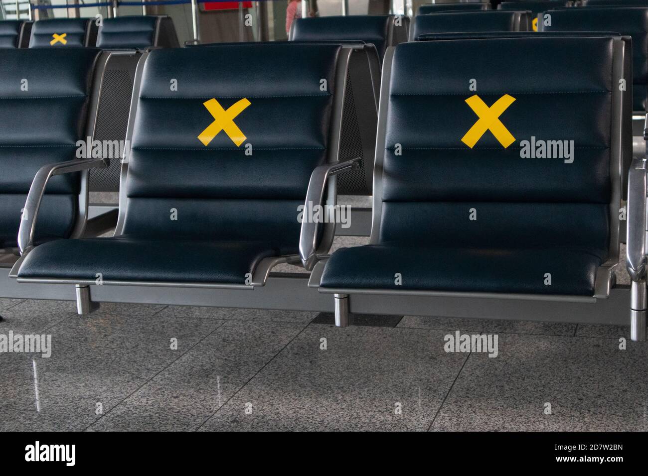 Está prohibido cerrar los asientos del aeropuerto con un cartel. Asientos vacíos en una sala del aeropuerto internacional durante una pandemia. Foto de stock