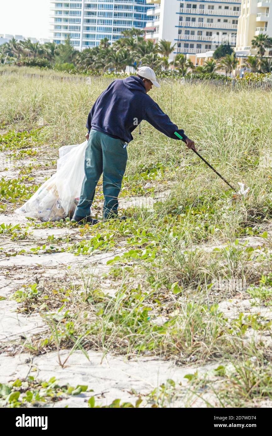 Trabajador de la ciudad recoge basura en dunas hechas por el hombre