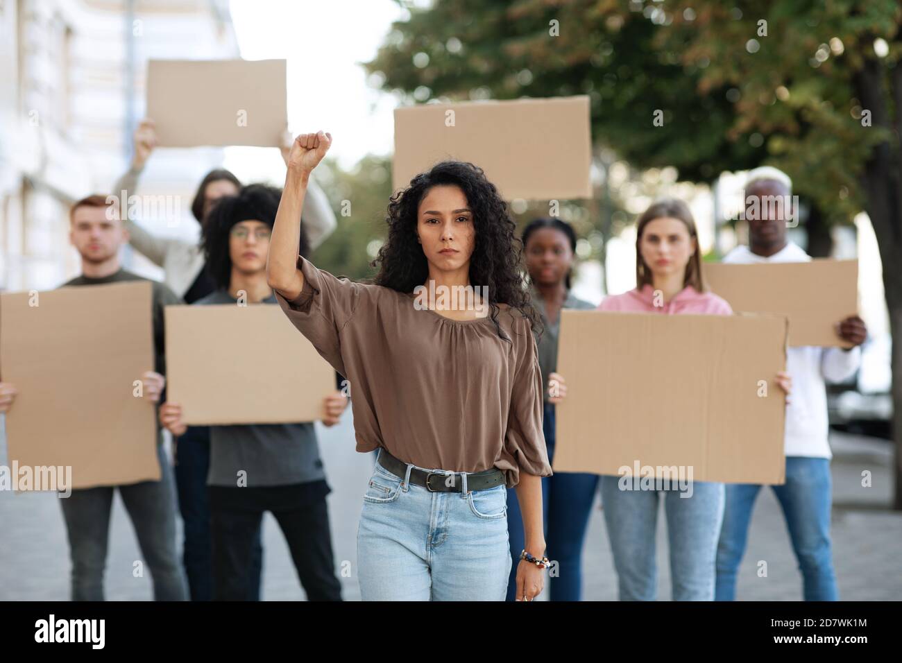 Mujer activa que dirige a un grupo de manifestantes en la calle Foto de stock