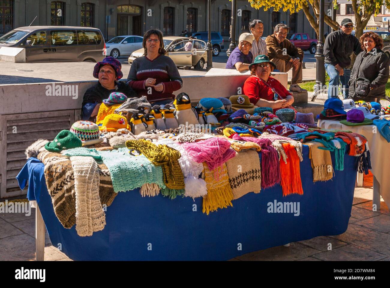 Punta Arenas, Chile - 12 de diciembre de 2008: Vendedores ambulantes venden  telas de lana de colores sobre la mesa azul cubierta a lo largo del camino  con los coches Fotografía de stock - Alamy